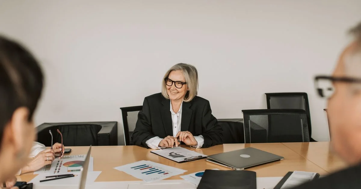 Une réunion d'affaires professionnelle avec des professionnels divers discutant de rapports dans un cadre de bureau moderne.