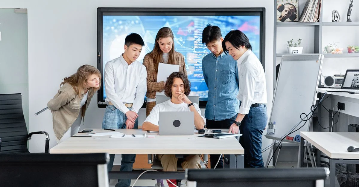 Équipe diversifiée collaborant sur un projet logiciel dans un bureau contemporain.