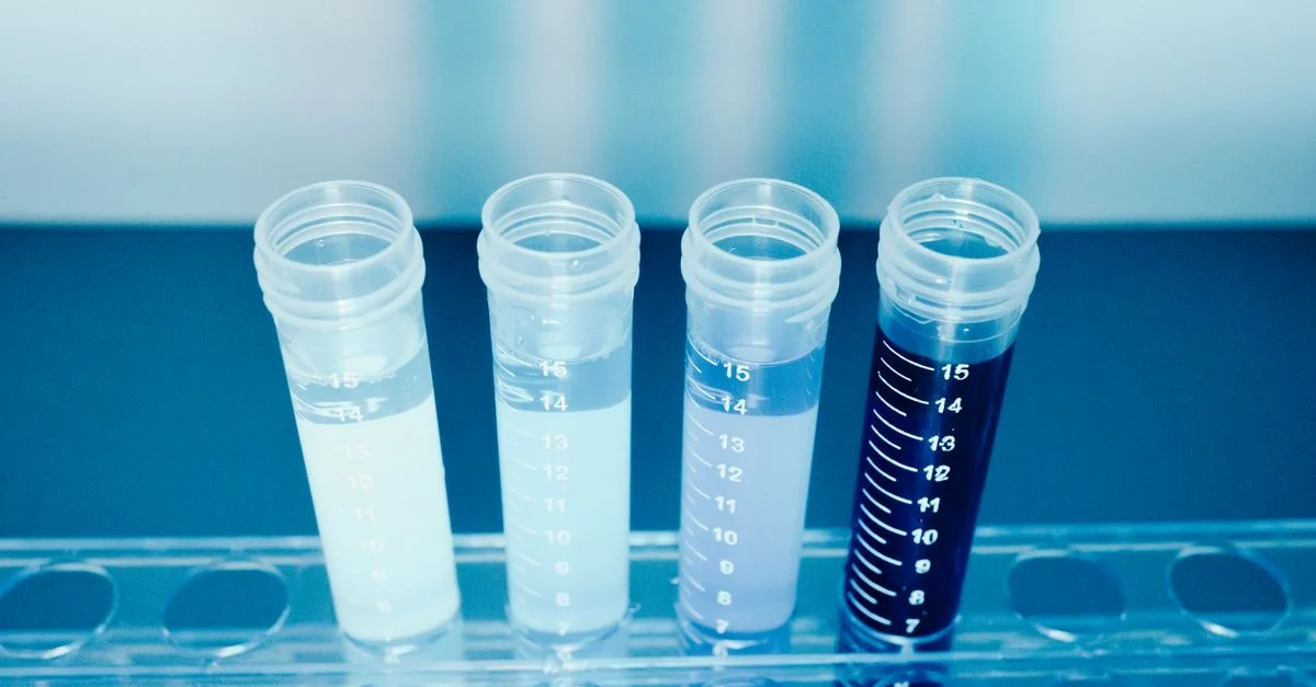 Gros plan de tubes à essai colorés dans un environnement de laboratoire pour la recherche médicale et scientifique.