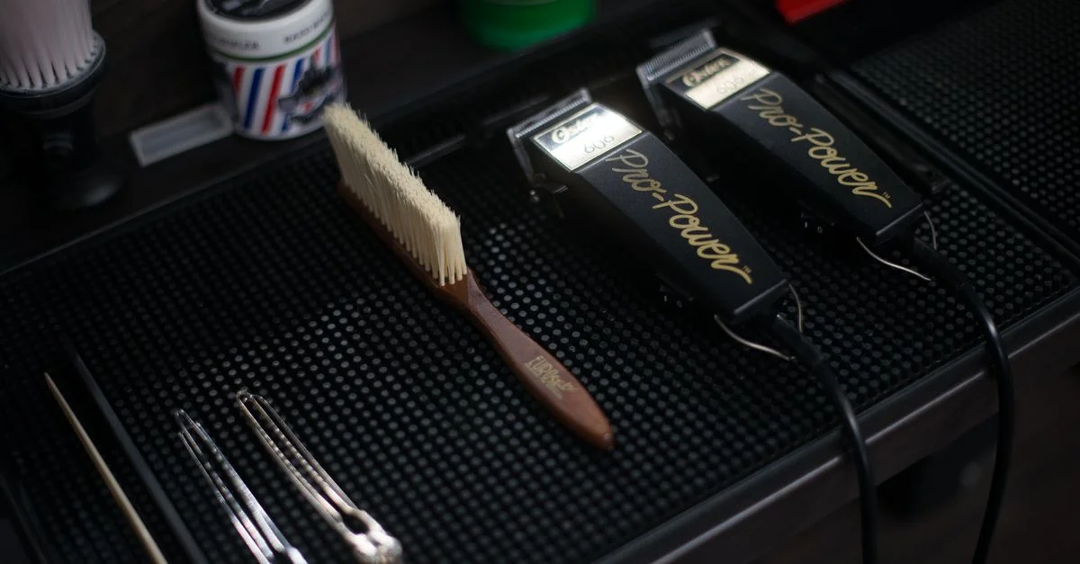 Gros plan sur des tondeuses à cheveux et des outils de grooming dans un salon de coiffure moderne.